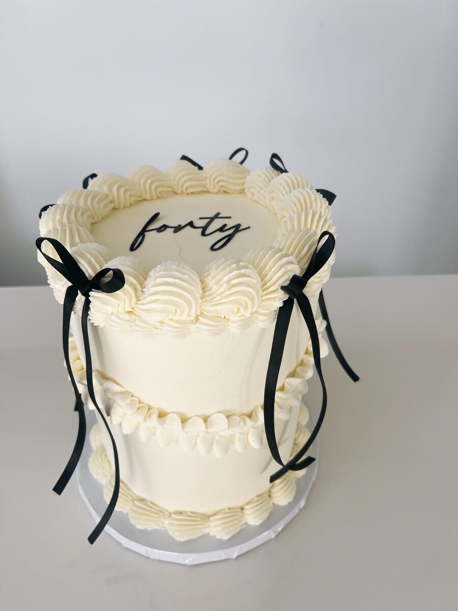 Elegant white fortieth birthday cake with black bows